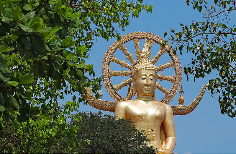 a picture of the famous historic statue of Buddha touching the sky at the phra yai temple on Koh Samui, thailand